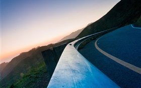 Asphalt road, fence, mountains, dusk HD wallpaper