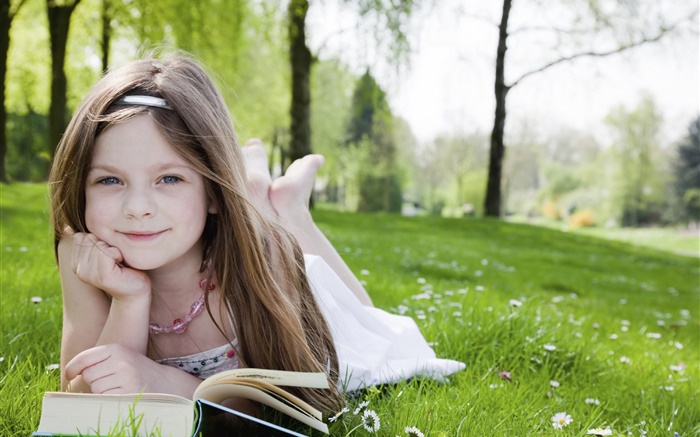 Cute little girl in the grass, read book Wallpapers Pictures Photos Images